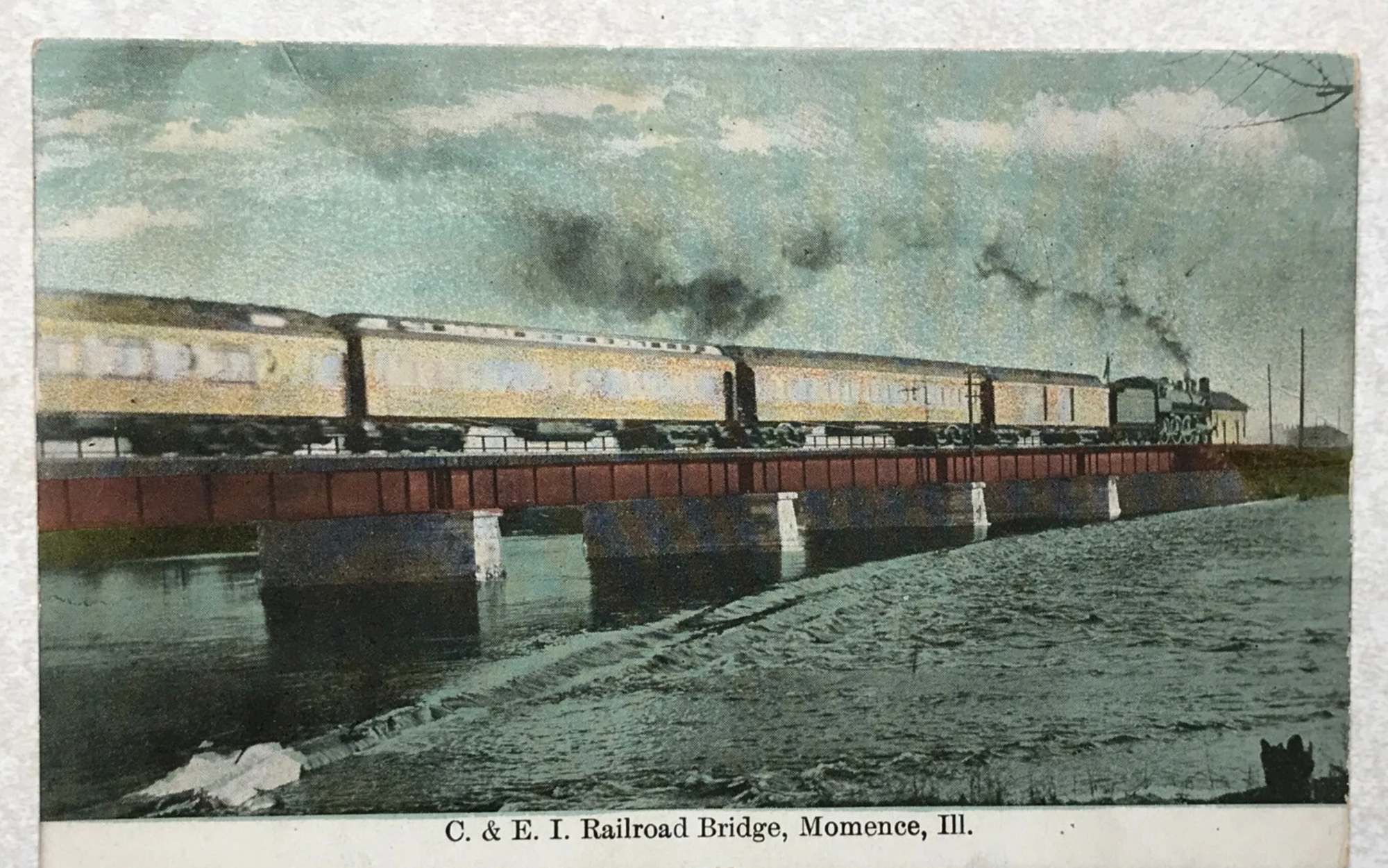 Vintage postcard: a steam train crossing the C. and E.I. Railroad bridge over the Kankakee at Momence