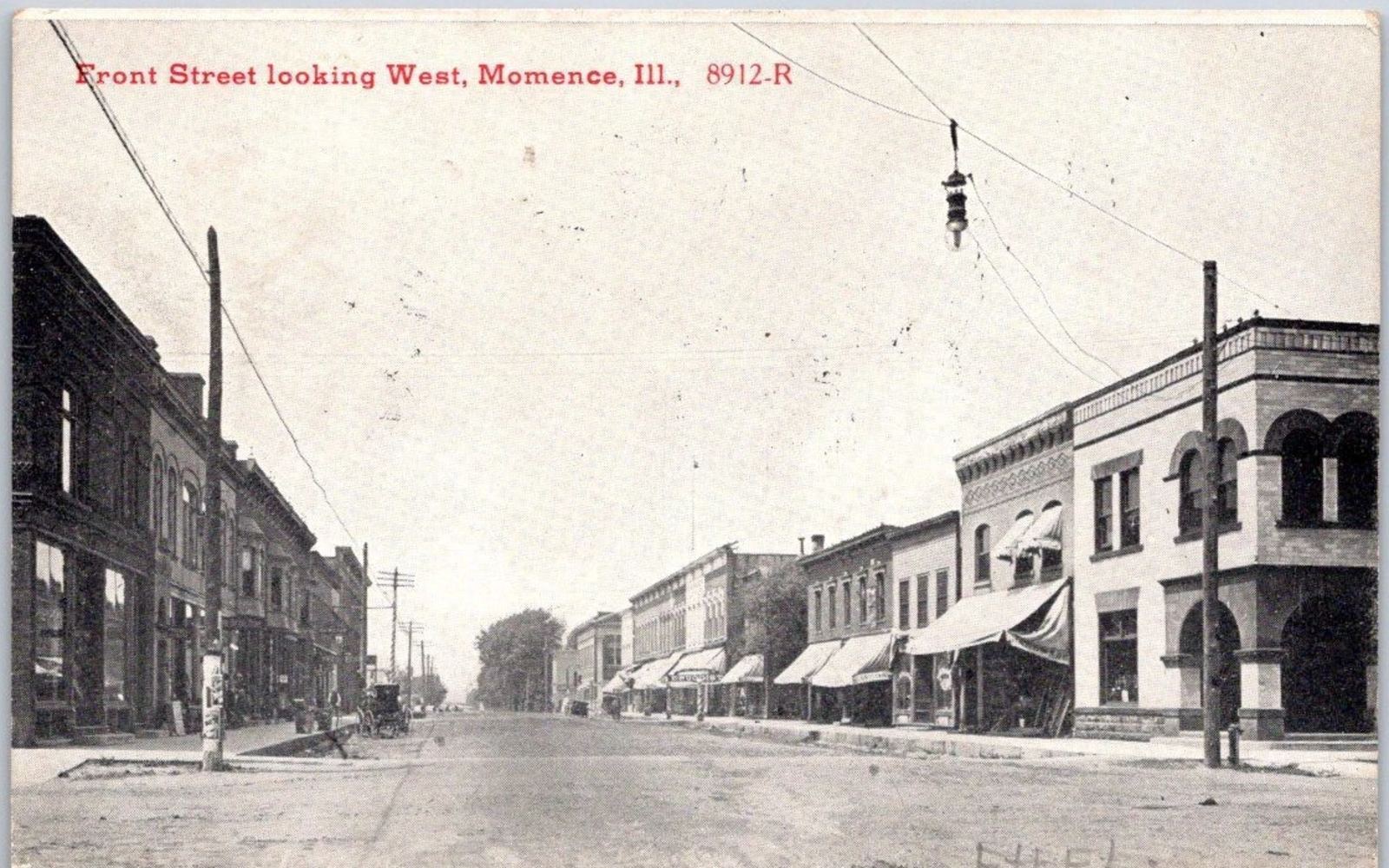 Vintage postcard: Front Street, Momence, looking west — dirt road, awnings and a horse-drawn buggy