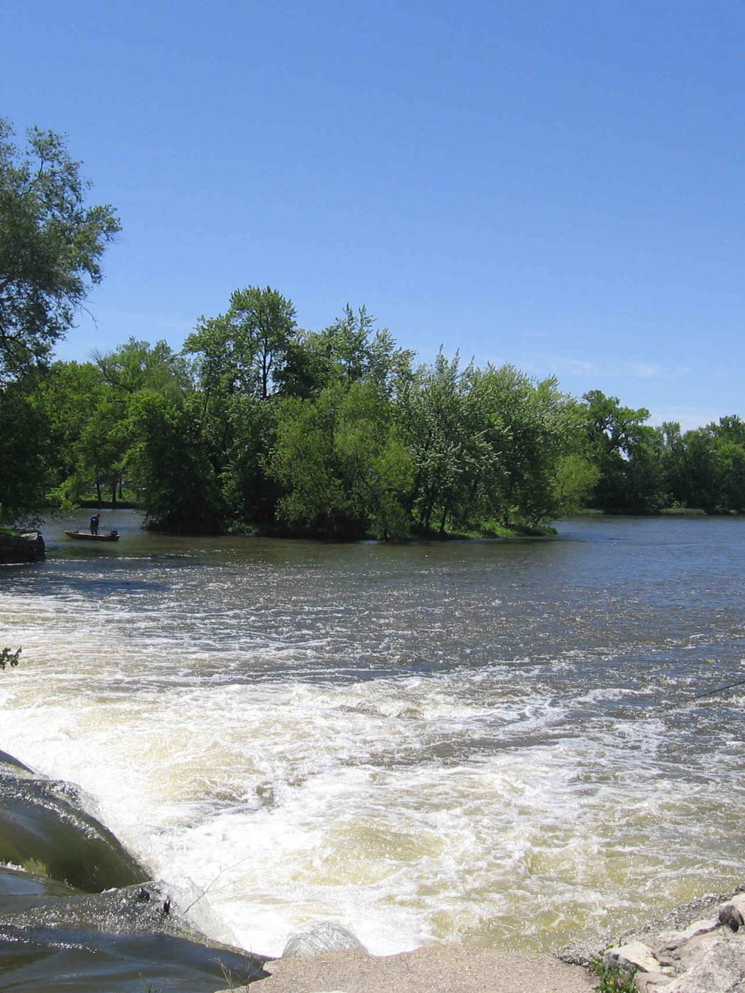 The Kankakee River spilling over the low dam at Momence, an angler on the bank
